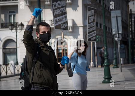 Während der Proteste am 21. März 2020 in Athen, Griechenland, rufen Menschen Slogans, tragen eine Schutzmaske und Handschuhe. Menschen versammelten sich vor dem griechischen Parlament auf dem Syntagma-Platz, um gegen Rassismus und Faschismus zu protestieren. (Foto von Nikolas Kokovlis/NurPhoto) Stockfoto