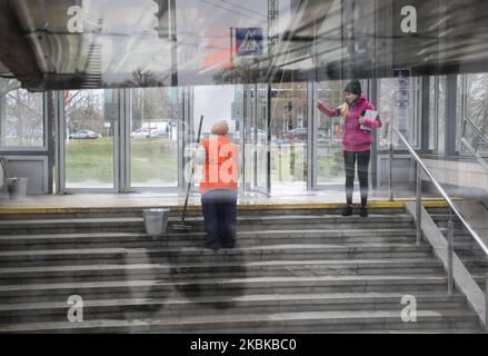 Eine Dienstfrau mit orangefarbener Weste wäscht den Eingang zum unterirdischen Grenzübergang in Kiew, Ukraine, 21. März 2020. Die ukrainische Hauptstadt Kiew unterbricht ab März 22 die Bewegung des öffentlichen Nahverkehrs, um die Ausbreitung des Coronavirus zu verhindern. (Foto von Sergii Chartschenko/NurPhoto) Stockfoto