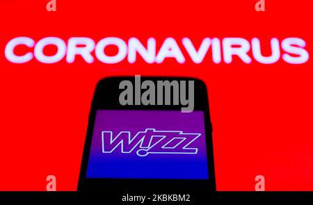 Das App-Symbol von Wizz Air ist auf dem Smartphone-Bildschirm mit dem Coronavirus-Zeichen im Hintergrund zu sehen. Dieses Bild wurde am 21. März 2020 in Polen aufgenommen. (Foto von Jakub Porzycki/NurPhoto) Stockfoto