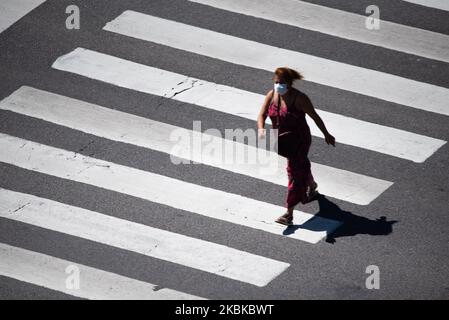 Eine Frau mit Maske geht am 22. März 2020 während der Quarantäne über die Avenida 9 de Julio in Buenos Aires, Argentinien, um die Verbreitung des Coronavirus zu verhindern (Foto: Mario De Fina/NurPhoto) Stockfoto