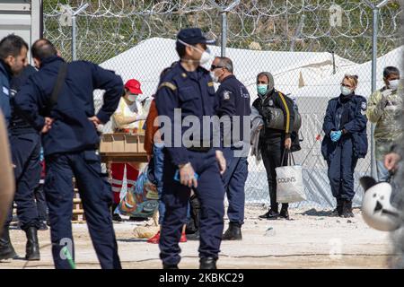 Flüchtlinge und Migranten warten, während sie ihre Bettdecken halten, um in ihre Zelte gebracht zu werden. Neues Flüchtlings- und Migrantenlager, temporäre Einrichtung mit Zelten, in Griechenland im Raum Kleidi in der Nähe des Dorfes Promahonas in der Region Serres, an der griechisch-bulgarischen Grenze, empfängt die erste Welle von Menschen, Asylbewerbern, die nach dem 1.. März 2020 nach Griechenland einreisen, wo das Land die Annahme von Asylanträgen eingestellt hat. Neuankömmlinge kommen von den Inseln Lesvos, Samos und Chios und wurden mit der Fähre nach Kavala und dann mit dem Bus nach Kleidi gebracht, um sie aufzunehmen, zu fotografieren, vorübergehend zu beherbergen und dann abzuschieben Stockfoto