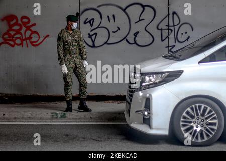 Ein Soldat überprüft Fahrzeuge an einer Straßensperre am fünften Tag der Bewegungskontrollbefehl (MCO) zur Bekämpfung des Covid-19-Ausbruchs in Kuala Lumpur, Malaysia, am 22. März 2020. (Foto von Mohd Daud/NurPhoto) Stockfoto