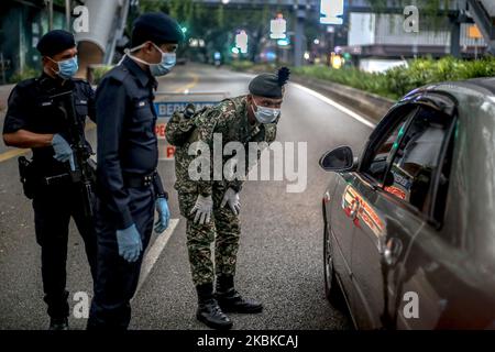 Malaysische Soldaten und Polizisten überprüfen Fahrzeuge an einer Straßensperre am fünften Tag der Bewegungskontrollbefehl (MCO) zur Bekämpfung des Covid-19-Ausbruchs in Kuala Lumpur am 22. März 2020. (Foto von Mohd Daud/NurPhoto) Stockfoto