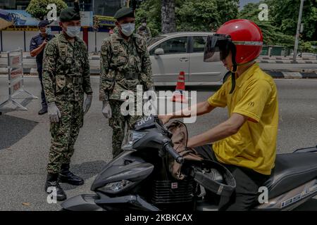 Ein malaysischer Soldat überprüft Fahrzeuge an einer Straßensperre am fünften Tag der Bewegungskontrollbefehl (MCO), um den Ausbruch von Covid-19 in Kuala Lumpur am 22. März 2020 zu bekämpfen. (Foto von Mohd Daud/NurPhoto) Stockfoto