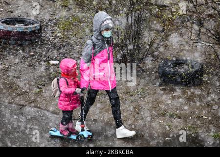 Menschen mit Schutzmasken als vorbeugende Maßnahme gegen das Coronavirus COVID-19 auf der Straße in Kiew, Ukraine, am 22. März 2020 (Foto: Maxym Marusenko/NurPhoto) Stockfoto