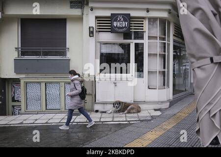 Eine Frau mit Gesichtsmaske überquert am 23. März 2020 einen geschlossenen Lebensmittelladen in Thessaloniki. Die GRIECHISCHE REGIERUNG K.Mitsotakis kündigte die Sperre des Landes Griechenland an, die am frühen Morgen des 23. März 2020 begann. (Foto von Achilleas Chiras/NurPhoto) Stockfoto