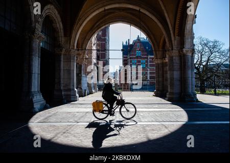 Eine Frau fährt am 23.. März 2020 mit ihrem Fahrrad am Rijksmuseum in Amsterdam vorbei, während der Coronavirus-Situation in den Niederlanden. (Foto von Romy Arroyo Fernandez/NurPhoto) Stockfoto