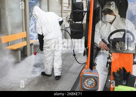 Ein Mitarbeiter der Municipal Cleaning Company (MPO) verwendet einen Druckschlauch, um Bus- und Straßenbahnhaltestellen mit Reinigungsmitteln gegen die Ausbreitung des Coronavirus zu desinfizieren. Krakau, Polen, am 23. März 2020. Seit März 13 befindet sich das Land in einer „epidemischen Bedrohung“. Dieser Status wurde nun zu einem „Seuchenzustand“ aufgewertet, der den Behörden die Möglichkeit geben wird, beispielsweise medizinisches Personal und andere Regierungsmitarbeiter zu verlegen und Transportbeschränkungen einzuführen. (Foto von Beata Zawrzel/NurPhoto) Stockfoto