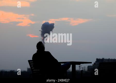 Am 20. März 2020 raucht ein Mann bei einem Sonnenuntergang im Bezirk Nowa Huta in Krakau, Polen, E-Zigarette. Seit März 13 befindet sich das Land aufgrund der Ausbreitung des Coronavirus in einer „epidemischen Bedrohung“. Dieser Status wurde nun zu einem „Seuchenzustand“ aufgewertet, und allen Menschen wird geraten, zur Quarantäne zu Hause zu bleiben und, wenn nicht nötig, keine Zeit im Freien zu verbringen. (Foto von Beata Zawrzel/NurPhoto) Stockfoto