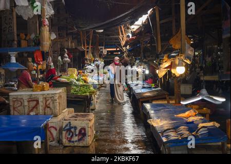 Bewohner kaufen am 24. März 2020 auf dem Manonda Traditional Market, Palu, Central Sulawesi, Indonesien ein. Die lokale Regierung beschränkt nicht die Betriebszeiten des größten traditionellen Marktes in Palu, sondern fordert Händler und Marktbesucher dazu auf, Transaktionen sicher durchzuführen, indem sie nach einer Transaktion immer Masken tragen und sich die Hände waschen, um die Ausbreitung des Coronavirus zu vermeiden. (Foto von Basri Marzuki/NurPhoto) Stockfoto