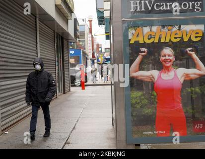 Am 25.. März 2020 wird in Queens, New York, ein Mann mit einer schützenden Gesichtsmask mit einem Straßenschild über HIV gesehen. (Foto von Selcuk Acar/NurPhoto) Stockfoto