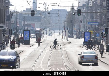 Ein allgemeiner Blick auf die Straße Menschen fahren Fahrrad und gehen in der Nähe von Meseumplein 27. März 2020 in Amsterdam, Niederlande. Der niederländische Minister für Justiz und Sicherheit Ferdinand Grapperhaus hat neue strengere Maßnahmen zur Bekämpfung der Ausbreitung des Coronavirus angeordnet, in Parks, Straßen und öffentlichen Räumen müssen die Menschen soziale Distanzierung üben und 1,5 Meter halten, dies für eine Gruppe von drei oder mehr Personen (die keine Familie sind) , Es wird eine Geldstrafe von 400 Euro ausgeteilt. (Foto von Paulo Amorim/NurPhoto) Stockfoto