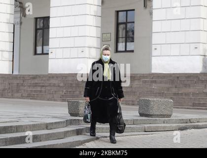 Eine Frau, die als vorbeugende Maßnahme gegen das COVID-19-Coronavirus eine Schutzmaske trägt, geht am 27. März 2020 in Kiew, Ukraine, spazieren. Um die Ausbreitung des Coronavirus COVID-19 einzudämmen, hat das Ministerkabinett von Ukrain bis zum 24. April 2020 ein 30-tägiges Notstandsregime auf dem gesamten Gebiet der Ukraine eingeführt. (Foto von STR/NurPhoto) Stockfoto