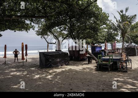 Touristen werden in der Nähe von Straßenverkäufern gesehen, da der Strand wegen des Ausbruchs der Coronavirus-Krankheit (COVID-19) am Kuta Beach in Bali, Indonesien, am 28 2020. März für die Öffentlichkeit geschlossen wurde. Der berühmte Strand von Kuta ist offiziell für Touristen geschlossen, um die Ausbreitung von COVID-19 zu verhindern. Dennoch brechen einige Touristen immer noch die Regel, den leeren Strand zu genießen. (Foto von Johanes Christo/NurPhoto) Stockfoto