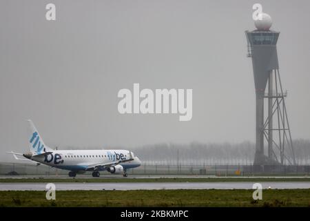 Flybe Embraer ERJ-175-Flugzeuge landen und Rollen auf dem internationalen Flughafen Amsterdam Schiphol. Das brasilianische Flugzeug hat die Registrierung G-FBJJ. Flybe war eine britische kommerzielle Fluggesellschaft mit einer Flotte von 63 Flugzeugen, die ihren Betrieb am 5. März 2020 aufgrund finanzieller Probleme und einer Verschlechterung des Passagierverkehrs aufgrund der Coronavirus Covid-19-Pandemie eingestellt hat. (Foto von Nicolas Economou/NurPhoto) Stockfoto