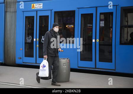 Ein Mann, der Vorräte trägt, trägt aufgrund der Ausbreitung des Coronavirus eine schützende Gesichtsmaske. Krakau, Polen, am 23. März 2020. Die polnische Regierung beschloss, im ganzen Land neue Beschränkungen einzuführen, wie beispielsweise Vorschriften, die das Verlassen der Heimat verhindern, sofern dies nicht gerechtfertigt ist. (Foto von Beata Zawrzel/NurPhoto) Stockfoto