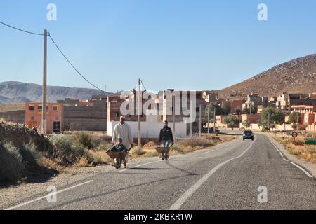 Berber Mann schiebt seinen Sohn in einer Schubkarre in einem kleinen Wüstendorf tief im Hohen Atlas in Marokko, Afrika. (Foto von Creative Touch Imaging Ltd./NurPhoto) Stockfoto