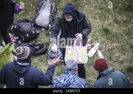 Eine Gruppe von Freiwilligen verteilt Hygieneartikel, Kleidung und andere Produkte an Obdachlose während der Ausbreitung des Coronavirus. Krakau, Polen, am 31. März 2020. Die polnische Regierung hat neue strenge Beschränkungen gegen COVID-19-Infektionen eingeführt, wie beispielsweise das Verlassen des Hauses zu verhindern, wenn dies nicht gerechtfertigt ist, Kindern unter 18 Jahren das Verlassen des Hauses zu verbieten, wenn sie nicht von einem Erwachsenen beaufsichtigt werden, Parks und Strände zu schließen und die meisten Hotels zu schließen. (Foto von Beata Zawrzel/NurPhoto) Stockfoto