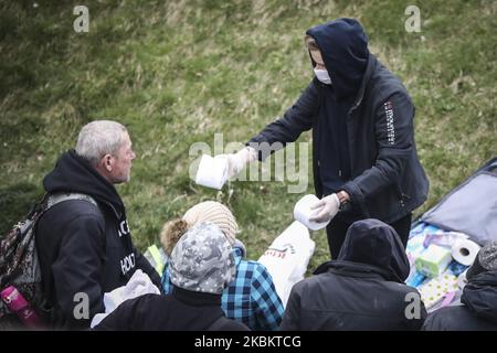 Eine Gruppe von Freiwilligen verteilt Hygieneartikel, Kleidung und andere Produkte an Obdachlose während der Ausbreitung des Coronavirus. Krakau, Polen, am 31. März 2020. Die polnische Regierung hat neue strenge Beschränkungen gegen COVID-19-Infektionen eingeführt, wie beispielsweise das Verlassen des Hauses zu verhindern, wenn dies nicht gerechtfertigt ist, Kindern unter 18 Jahren das Verlassen des Hauses zu verbieten, wenn sie nicht von einem Erwachsenen beaufsichtigt werden, Parks und Strände zu schließen und die meisten Hotels zu schließen. (Foto von Beata Zawrzel/NurPhoto) Stockfoto