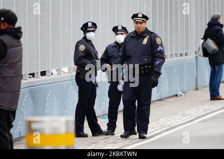 Eine Gruppe von Personen, die den USNS Comfort und die NYPD-Beamten auscheckten, zerstreut sie als „Anti-Coronavirus“-Maßnahme am 31. März 2020 in New York, USA. Laut Daten der Johns Hopkins University gibt es in den USA mehr Coronavirus-Fälle als in jedem anderen Land der Welt mit 184.000 bestätigten Infektionen. New York ist jetzt mit 75.795 bestätigten Fällen zum neuen Epizentrum des Ausbruchs in der Welt geworden. (Foto von John Nacion/NurPhoto) Stockfoto