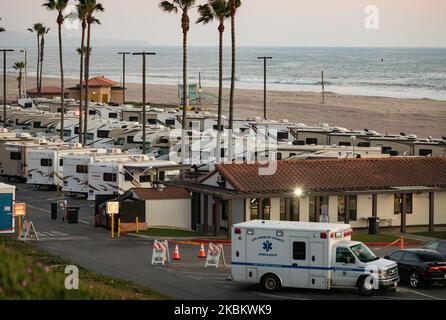 Am 1.. April 2020 kommt ein Krankenwagen auf einem Parkplatz am Strand an, der zusammen mit R.V's als Isolationszone für Menschen mit COVID-19 am Dockweiler State Beach in Los Angeles, Kalifornien, genutzt wird. Personen, die sich aufgrund von Obdachlosigkeit nicht selbst isolieren können oder in einem Haus mit hochgefährdeten Familienmitgliedern leben können, inmitten der Coronavirus-Pandemie, nutzen die Camper als sichere Zuflucht vor dem Virus. (Foto von John Fredricks/NurPhoto) Stockfoto