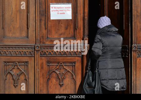 Eine Dame tritt in die Kirche des heiligen Franziskus von Assisi ein, nachdem sie eine Kerze vor dem „Fenster des Papstes“ im Erzbischöflichen Palast in Krakau hinterlassen hat, wo Papst Jean Paul II. Während seiner Besuche in Krakau die Menschenmassen angesprochen hat. Heute jährt sich der Tod von Papst Johannes Paul II. Zum 15.. Mal. Er starb am 2. April 2005 im Alter von 84 Jahren, und sein Pontifikat dauerte 26 Jahre, 5 Monate und 16 Tage. Am Donnerstag, den 2. April 2020, in Krakau, Polen. (Foto von Artur Widak/NurPhoto) Stockfoto
