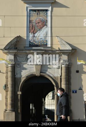 Ein Mann, der eine Schutzmaske trägt, geht am „Fenster des Papstes“ im Erzbischöflichen Palast in Krakau vorbei, wo Papst Jean Paul II. Während seiner Besuche in Krakau die Menschenmassen ansprach. Heute jährt sich der Tod von Papst Johannes Paul II. Zum 15.. Mal. Er starb am 2. April 2005 im Alter von 84 Jahren, und sein Pontifikat dauerte 26 Jahre, 5 Monate und 16 Tage. Am Donnerstag, den 2. April 2020, in Krakau, Polen. (Foto von Artur Widak/NurPhoto) Stockfoto