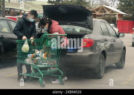 Menschen, die Gesichtsmasken tragen, um sie vor dem neuartigen Coronavirus (COVID-19) zu schützen, als sie am 03. April 2020 in Toronto, Ontario, Kanada, Lebensmittel in ihr Auto laden. Die Provinz Ontario hat heute ihre Prognosen für COVID-19 veröffentlicht, nach deren Schätzungen in Ontario in den nächsten zwei Jahren zwischen 3.000 und 15.000 Todesfälle aufgrund des Virus zu verzeichnen sein werden. Bis heute hat die Provinz 3.255 Fälle des Virus gemeldet, darunter 1.023 Genesungen und 67 Todesfälle, aber es gab Dutzende von zusätzlichen Todesfällen, die von den Gesundheitsbehörden der Provinz nicht gemeldet wurden. (Foto von Creative Touch Imaging L Stockfoto