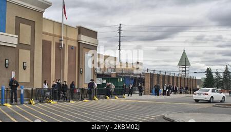 Menschen tragen Gesichtsmasken und Gummihandschuhe, um sie vor dem neuartigen Coronavirus (COVID-19) zu schützen, während sie soziale Distanzierung (physische Distanzierung) üben, während sie am 03. April 2020 in einem Walmart-Geschäft in Toronto, Ontario, Kanada, eintreffen. Angesichts der zunehmenden Verbreitung von COVID-19 in Kanada beschränken viele Lebensmittelgeschäfte die Anzahl der Personen, die gleichzeitig in das Unternehmen einreisen dürfen, um soziale Distanzierungen (physische Distanzierungen) zu fördern und durchzusetzen. Heute veröffentlichte die Provinz Ontario ihre Prognosen für COVID-19, die schätzen, dass es zwischen 3.000 und 15.000 Todesfälle in Ontario aufgrund von t geben wird Stockfoto