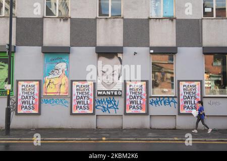 Eine Frau geht am 6. April 2020 im Northern Quarter, Manchester City Centre, England, an einigen beruhigenden Straßenkunstarbeiten vorbei und sagt: „BITTE GLAUBEN SIE, DASS DIESE TAGE VERGEHEN werden“. (Foto von Pat Scaasi/MI News/NurPhoto) Stockfoto