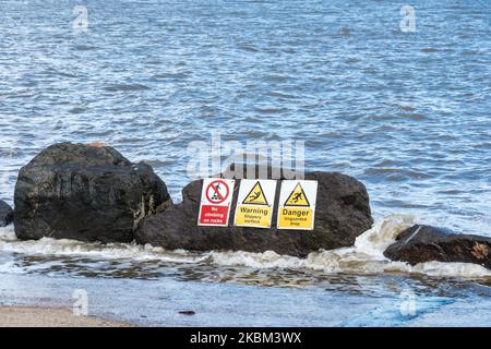 Felsen am unbewachten Rand der Parade an der Meeresmauer mit Warnschildern Lowestoft suffolk 2022 Stockfoto