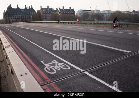 Ein Radfahrer fährt am 8. April 2020 über eine nahe verlassene Westminster Bridge in London, England. Da das Land seinen Covid-19-Coronavirus-„Höhepunkt“ für eine weitere Woche oder länger nicht erreichen wird, wird erwartet, dass sich die derzeitigen Sperrbedingungen in ganz Großbritannien in den kommenden Tagen nach dem bevorstehenden Ende, am kommenden Montag, Der ursprünglich verhängten dreiwöchigen Restriktionen. Der Außenminister Dominic Raab soll sich auf der täglichen Pressekonferenz am Donnerstag mit dieser Angelegenheit befassen. Raab ist derzeit im Amt des Premierministers Boris Johnson, der die Tests durchgeführt hat Stockfoto