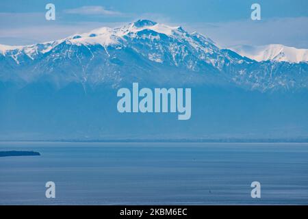 Schneebedeckter Olymp wie von Thessaloniki aus gesehen, liegt der Berg nach dem seltenen Wetter und dem Schneefall im April hinter dem Meer, dem Thermaikos Golf. Der Olymp ist der höchste Berg Griechenlands mit einer Höhe des höchsten Gipfels, Mytikas mit 2918m. Mt. Der Olymp war nach der antiken griechischen Mythologie die Heimat der griechischen Götter. Heute ist der Berg bekannt für die reiche Artenvielfalt, reiche Flora und ist ein Nationalpark, der erste in Griechenland seit 1938. Der Berg ist ein beliebtes Sommer- und Winterziel zum Wandern, Trekking, Klettern, aber auch für Touristen, da es reich fo sind Stockfoto