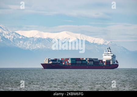 Ein Frachtschiff, das von der Küste der Stadt Thessaloniki aus gesehen wurde, ankerte am Golf von Thermaikos, Ägäis in Griechenland am 7. April 2020. Das Frachtschiff trägt Container-Versand und ist unter dem Namen EF Emira, mit IMO-Registrierungsnummer 9357810, segelt unter der Flagge der Marshall-Inseln. Das Schiff wartet auf die Entladung seiner Waren im Hafen von Thessaloniki, dem zweitgrößten Containerhafen in Griechenland, aber es gibt eine Verzögerung im Hafen aufgrund der Coronavirus-Pandemie Covid-19. Im Hintergrund ist der schneebedeckte Olymp zu sehen. (Foto von Nicolas Economou/NurPhoto) Stockfoto