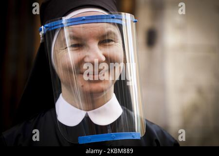 Eine Nonne, die einen schützenden Gesichtsschutz trägt, wird gesehen, während die Kanoninnen des Heiligen Geistes während der Ausbreitung des Coronavirus Nahrung an Arme und Obdachlose verteilen. Krakau, Polen, am 10.. April 2020. (Foto von Beata Zawrzel/NurPhoto) Stockfoto