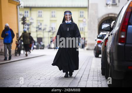 Eine Nonne, die einen schützenden Gesichtsschutz trägt, wird gesehen, während die Kanoninnen des Heiligen Geistes während der Ausbreitung des Coronavirus Nahrung an Arme und Obdachlose verteilen. Krakau, Polen, am 10.. April 2020. (Foto von Beata Zawrzel/NurPhoto) Stockfoto