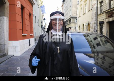 Eine Nonne, die einen schützenden Gesichtsschutz trägt, wird gesehen, während die Kanoninnen des Heiligen Geistes während der Ausbreitung des Coronavirus Nahrung an Arme und Obdachlose verteilen. Krakau, Polen, am 10.. April 2020. (Foto von Beata Zawrzel/NurPhoto) Stockfoto