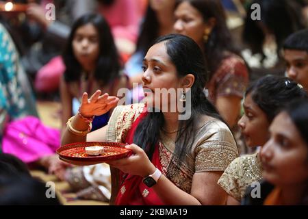 Hindu-Anhänger führen aarti am BAPS Shri Swaminarayan Tempel während des Annakut Darshan (auch bekannt als Annakut Utsav und Govardhan Puja) durch, der am fünften und letzten Tag des Festivals von Diwali stattfindet, Dies markiert den Beginn des Hindu-Neujahrs in Toronto, Ontario, Kanada am 28. Oktober 2019. Annakut, was einen „großen Berg an Nahrung“ bedeutet, der Gott als Zeichen der Hingabe angeboten wird. BAPS (Bochasanwasi Shri Akshar Purushottam Swaminarayan Sanstha) ist eine Sekte der Hinduismus-Diksha Vidhi und deren Tempel, obwohl sie vielen Hindu-Gottheiten gewidmet sind, auch als Gemeinschaft und als lernender dienen Stockfoto