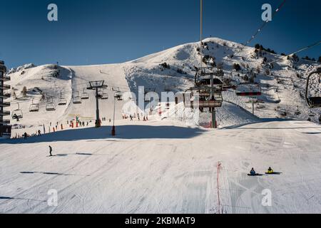 Skifahrer und Sessellifte im Skidorf und Skifahrer auf der Piste Skipisten mit Snowboardern Frankreich die Alpen Stockfoto