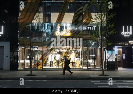 Ein Büroangestellter, der eine OP-Maske trägt, kommt an geschlossenen Geschäften entlang der Hauptstraße in Ginza, Tokio, vorbei, 10. April. Viele Geschwüre schlossen Fensterläden, nachdem ein staatlicher Notfall für die japanische Hauptstadt und andere städtische Gebiete des Landes erklärt wurde, um das Coronavirus einzudämmen. (Foto von Yusuke Harada/NurPhoto) Stockfoto