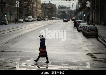 Eine Frau mit Schutzmaske überquert am 14. April 2020 während des Coronavirus-Notfalls eine leere Straße im Zentrum von Sankt Petersburg, Russland. (Foto von Valya Egorshin/NurPhoto) Stockfoto