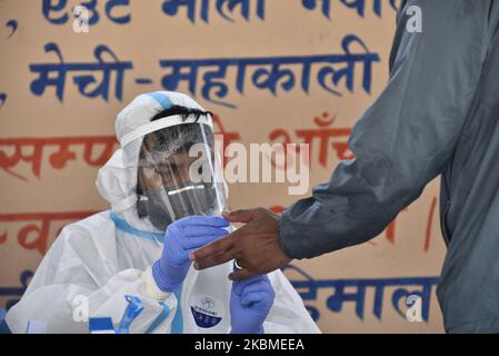 Ein Gesundheitsmitarbeiter in Schutzkleidung nimmt am Mittwoch, den 15. April 2020, eine Blutprobe eines Mannes auf einen Corona-Virus (COVID-19)-Schnelltest in Bungamati, Lalitpur, Nepal, ab. (Foto von Narayan Maharjan/NurPhoto) Stockfoto