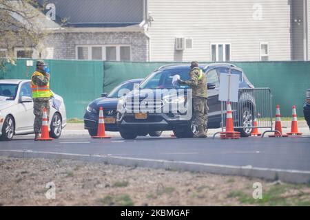 Mitglieder der Nationalgarde helfen Autofahrern bei der Ankunft in einem COVID-19-Testzentrum, das auf dem Parkplatz der Aqueduct Racetrack im New Yor?k City Borough of Queens, NY, eingerichtet wurde, 16. April 2020. (Foto von John Nacion/NurPhoto) Stockfoto