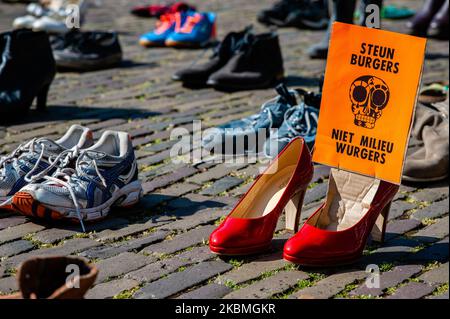 Während der symbolischen Aktion, die die Klima-Aktivistengruppe XR am 17.. April 2020 vor dem Repräsentantenhaus in Den Haag, Niederlande, durchgeführt hat, hält ein Paar rote Schuhe einen XR-Flyer in der Hand. (Foto von Romy Arroyo Fernandez/NurPhoto) Stockfoto