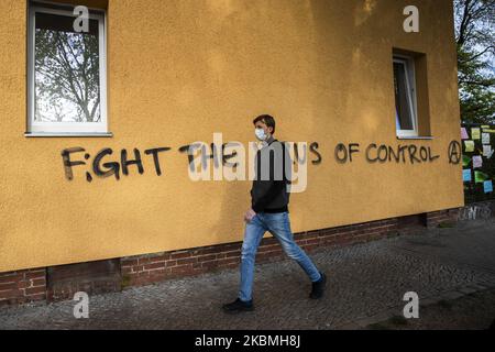 Ein Mann geht an einer Graffiti vorbei, in der es heißt: „Kampf gegen den Virus der Kontrolle“, das am 17. April 2020 an einer Hauswand in Berlin zu sehen ist. (Foto von Emmanuele Contini/NurPhoto) Stockfoto