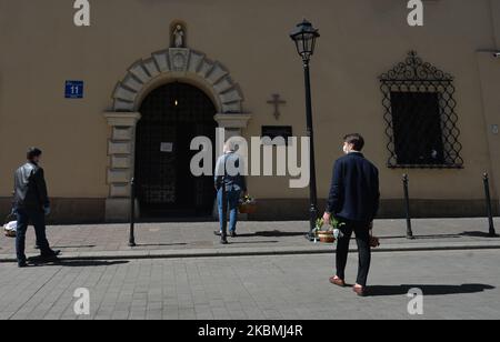 Am Karsamstag erwarten die Menschen draußen, in Krakau in eine orthodoxe Kirche zur Kreuzerhöhung einzutreten. Die jährliche traditionelle Segnung der Osterkörbe findet statt, aber ohne dass Menschen den Segen aufgrund der Coronavirus-Krisen unterstützen. Am Samstag, den 18. April 2020, in Krakau, Woiwodschaft Kleinpolen, Polen. (Foto von Artur Widak/NurPhoto) Stockfoto