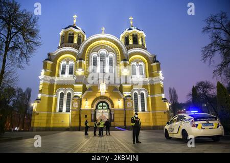 Polizeibeamte in Schutzmasken stehen vor der Wolodymysky-Kathedrale, um zu verhindern, dass sich vor dem orthodoxen Osterdienst während des COVID-19-Ausbruchs der Koronarerkrankung in Kiew, Ukraine, am 18. April 2020 eine große Anzahl von Menschen versammeln könnte. (Foto von Maxym Marusenko/NurPhoto) Stockfoto