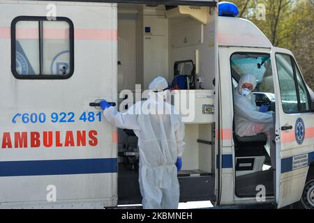 Medizinische Mitarbeiter in Hasmatanzügen, Schutzhelmen und Masken warten auf dem Parkplatz der Abteilung für Infektionskrankheiten des Universitätskrankenhauses in Krakau, nachdem sie mit einem Patienten, der verdächtigt wurde, sich mit dem Coronavirus infiziert zu haben, eintreffen. Am Dienstag, den 21. April 2020, in Krakau, Polen. (Foto von Artur Widak/NurPhoto) Stockfoto