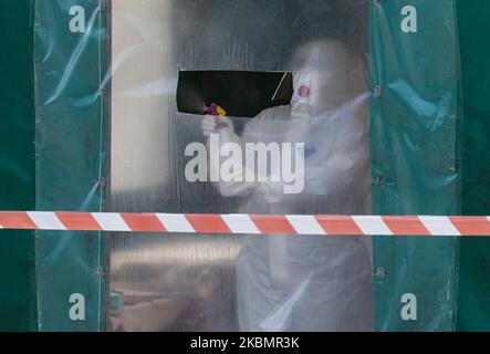 Ein Epidemiologe desinfiziert das Zelt, das neben dem Wohnhaus aus der sowjetzeit aufgestellt wurde, wo der Ausbruch der COVID-19 entdeckt wurde und 38 Infektionsfälle in der Stadt Vyshneve in der Nähe von Kiew, Ukraine, am 22. April 2020 bestätigt wurden. Das Ministerkabinett der Ukraine hat die Quarantänemaßnahmen bis Mitte Mai verlängert und alle Präventivmaßnahmen eingeführt, da 6592 Fälle von COVID-19-Coronavirus-Krankheit im Land bestätigt wurden (Foto: Sergii Kharchenko/NurPhoto) Stockfoto