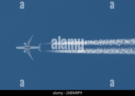 Eine Boeing 777F von Emirates Sky Cargo, die am 23. April 2020 am blauen Himmel über der Stadt Thessaloniki, Griechenland, überflog und Kontrahenten oder Chemtrails bildete, hinter denen weißer Dampf stand. Bei dem Flugzeug handelt es sich um eine Boeing B777-F1H mit der Registrierung A6-EFF, die um 34,000feet Uhr vom internationalen Flughafen Dubai, VAE DXB, nach Madrid, Spanien, MAD fliegt und Frachtgüter während der COVID-19 Coronavirus-Pandemie transportiert. Emirates SkyCargo ist der Luftfrachtbereich von Emirates Airlines. (Foto von Nicolas Economou/NurPhoto) Stockfoto